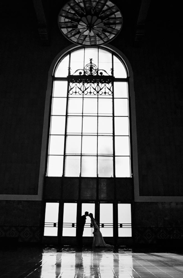 Far away shot of bride and groom under window - wedding photo by top Austin based wedding photographers Q Weddings
